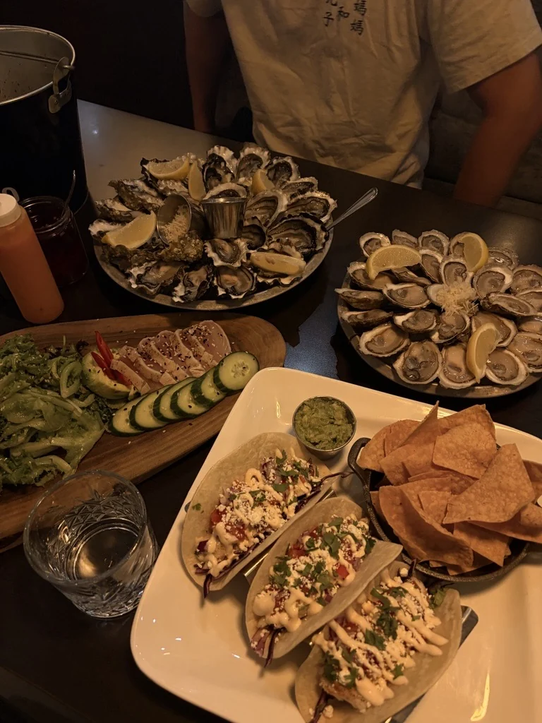 Two platters of oysters and shared dishes at Diana's
