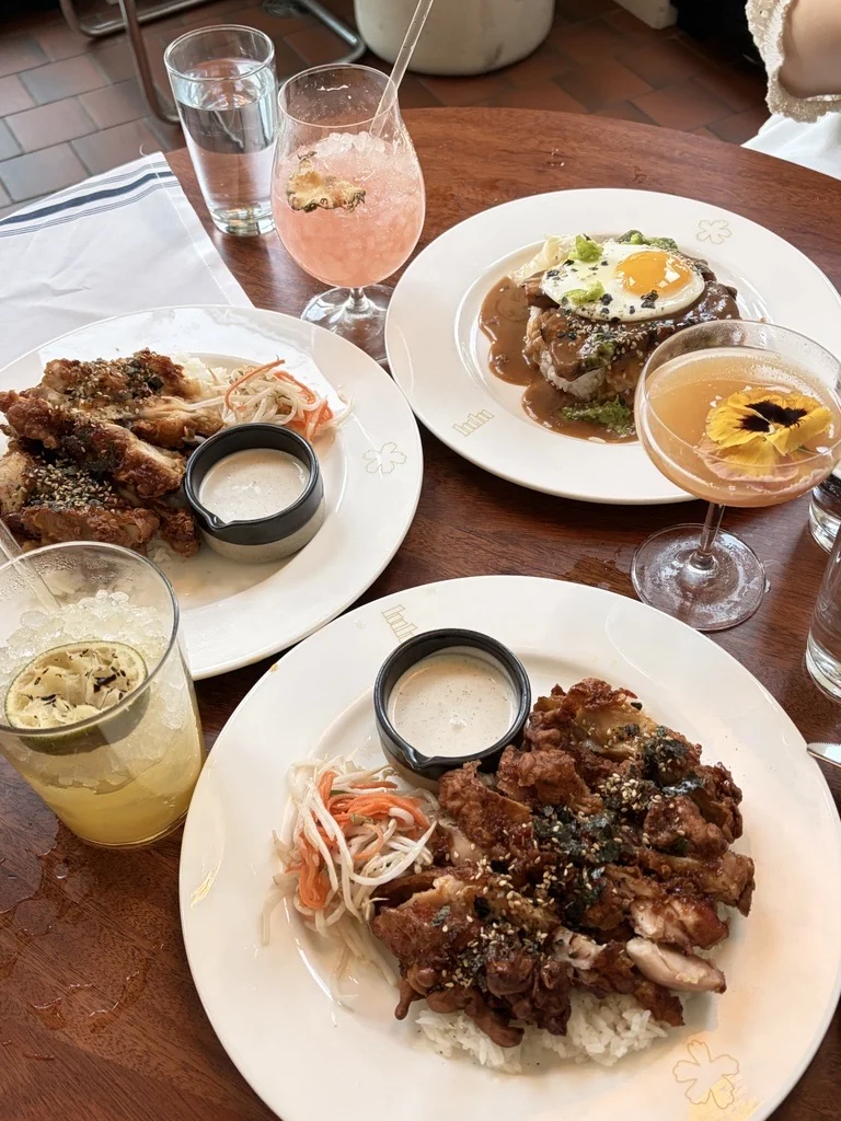 Plates of fried chicken and rice with colourful drinks at Lulu Bar