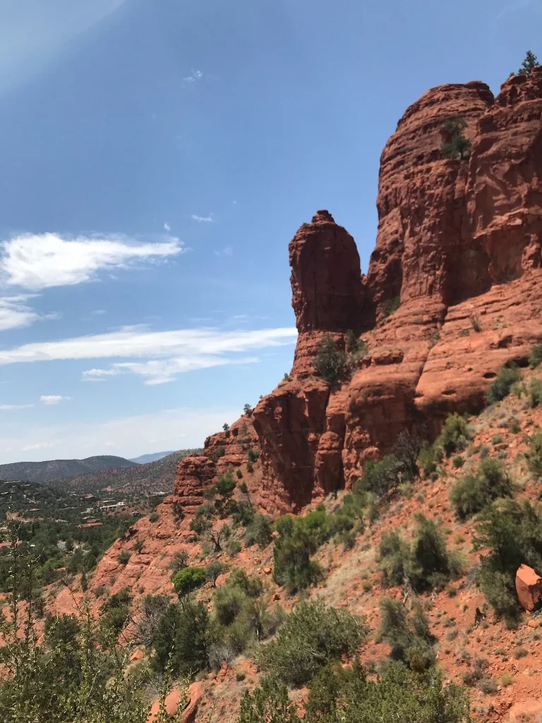Red rock formations rising beside a desert trail
