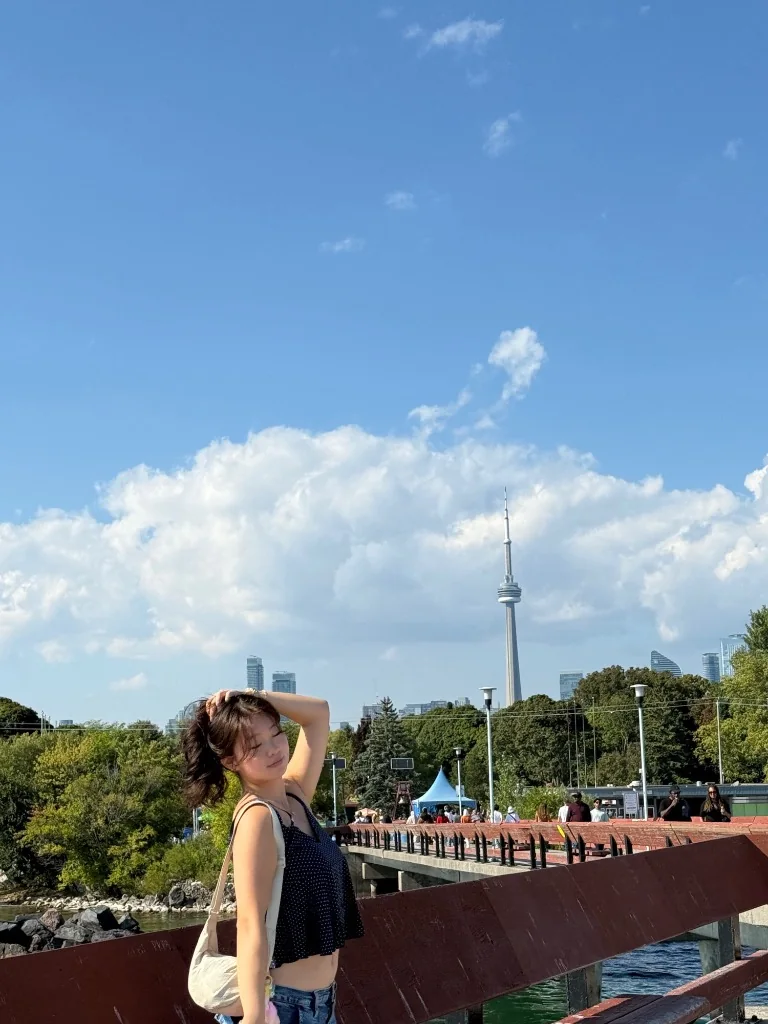 Amanda standing by the water with the Toronto skyline behind her